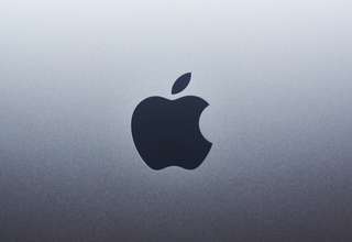 MacBook and iPhone displaying VPN security protection shield icon on screen