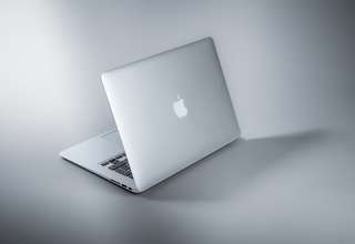 Person setting up VPN on MacBook laptop for secure browsing and privacy protection