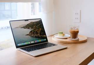 MacBook user connecting to public Wi-Fi network in coffee shop with VPN protection