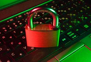 Digital encryption shield protecting Apple MacBook and iPhone from cyber threats